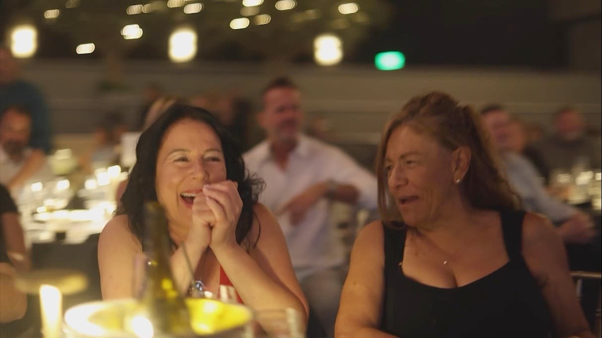 Two women laughing at a comedy show
